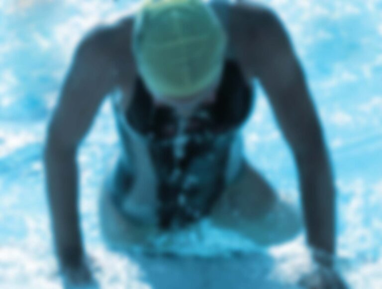 A woman gets out of the pool to start her bike.