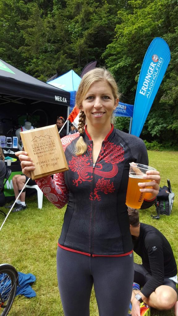 Kara Hobby drinking beer at the finish line of the Shawnigan Lake triathlon while drinking a well deserved beer.