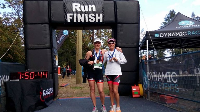 April Vesey and Sharon Craig showing off their medals at the finish line of the Cultus Lake Triathlon
