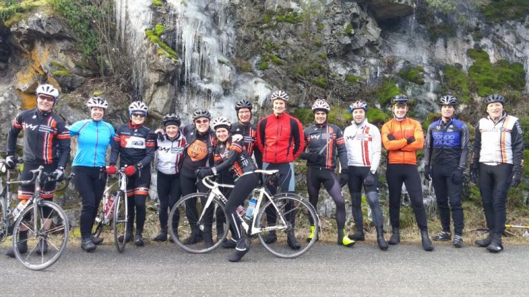 human powered racing athletes pose in front of ice while on their saturday ride at the observatory
