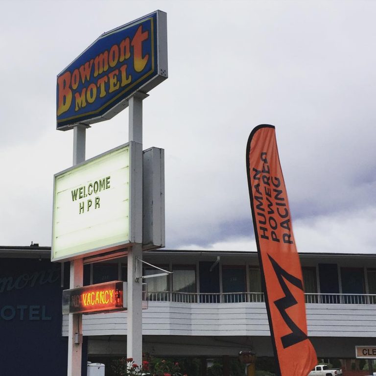 Outside of a motel in Kelowna a tall sign reads "Bowmont Motel" in large letters and beneath it a smaller signs says welcome "HPR"