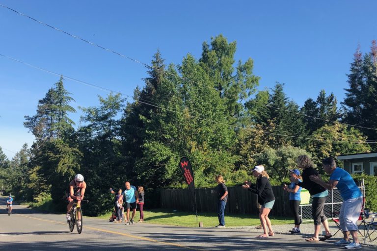 Mike Neill riding past HPR cheer station at Jay Kriegers house on bike at Victoria 70.3