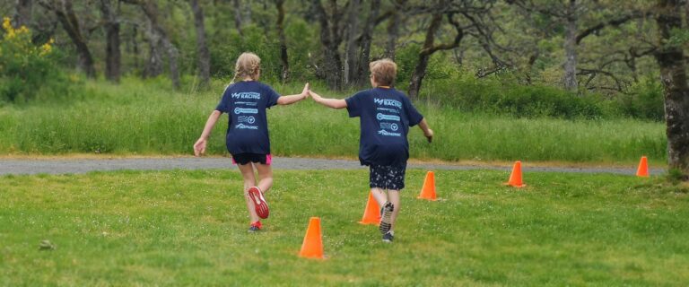 A racer shares a high five with an athlete that is already done at the youth triathlon in the West Shore.