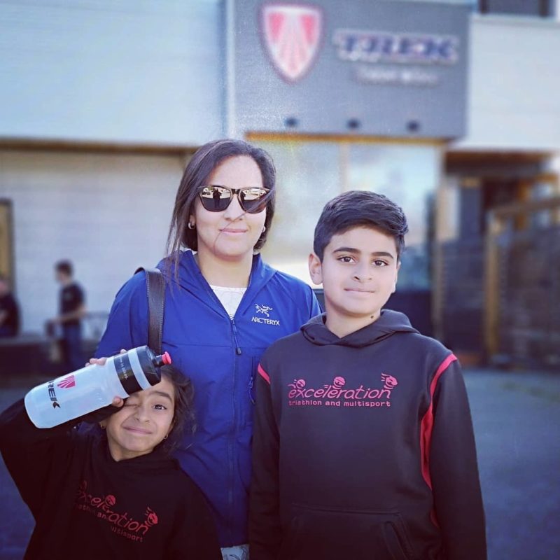 A mom and her son smiling shoulder to shoulder outside of Trek Pro City Cycles.