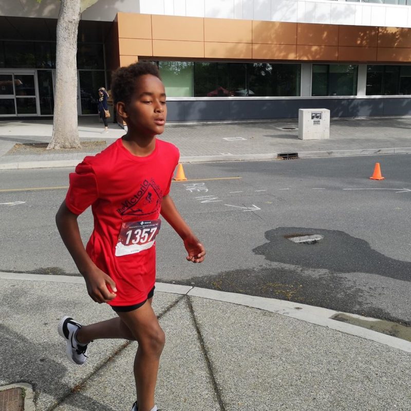 A young boy runs past the CARSA building on the UVic campus.
