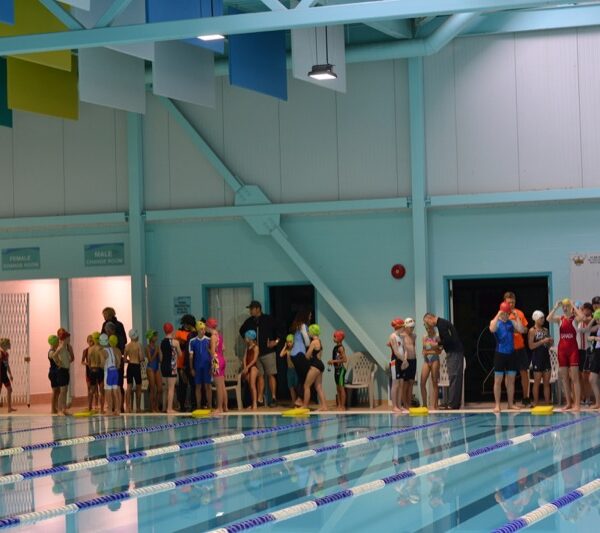 Athletes and volunteers line up along the wall at the gym to start.