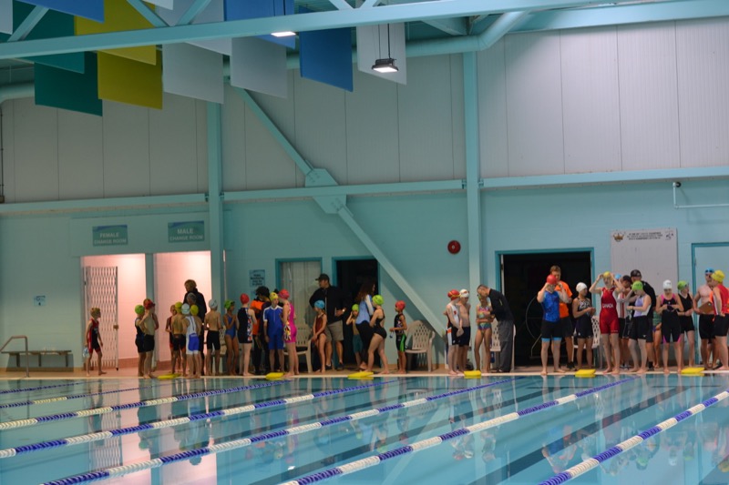 Athletes and volunteers line up along the wall at the gym to start.