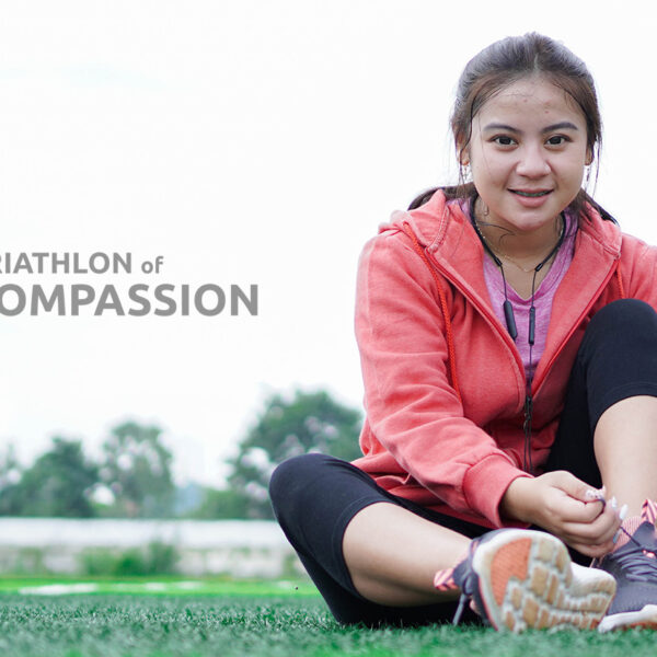 A young woman laces up her shoes in preparation for the Tri of Compassion.