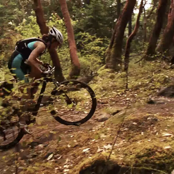 XTERRA athlete charges up a hill on her bike.