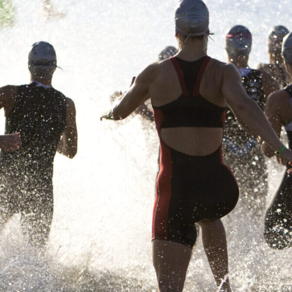 Triathletes At Start of Triathlon Running Into The Water.