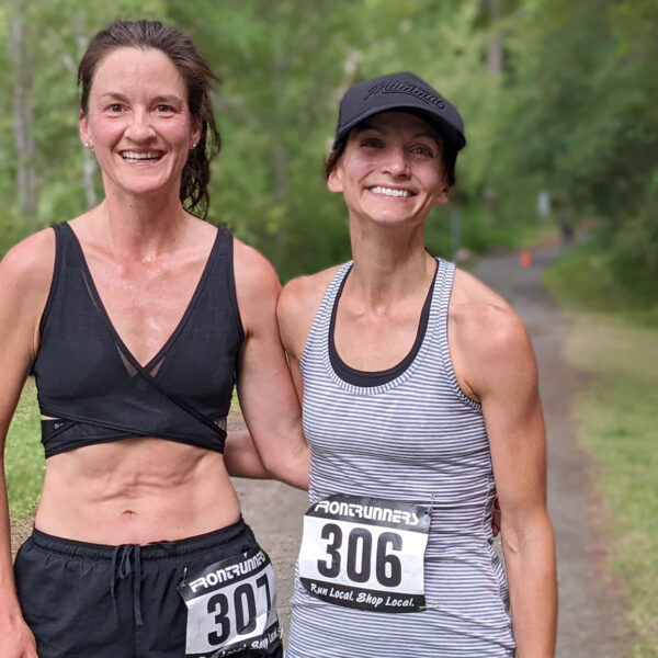 Two Victoria Trail Runners stand arm in arm at the end of the race.