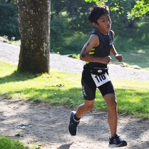 A youth triathlon racer burns up the hill on the run.