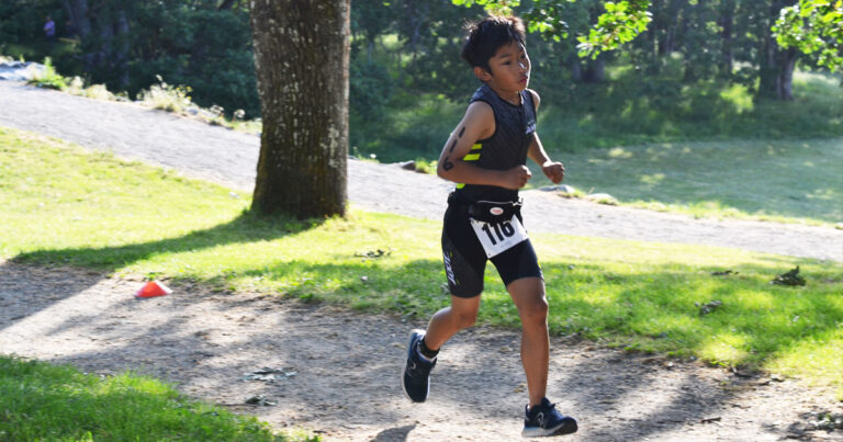 A youth triathlon racer burns up the hill on the run.