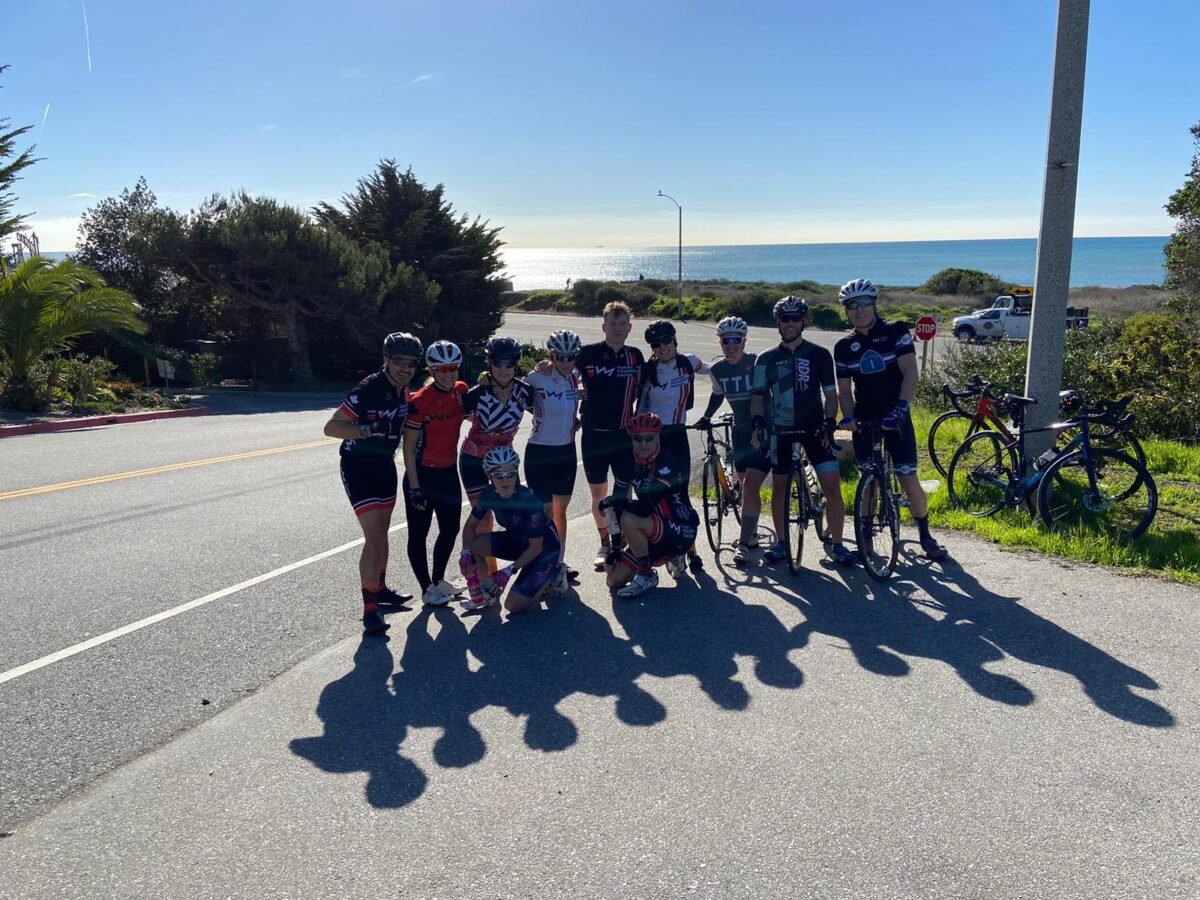 group of cyclist at roadside with the ocean in the background