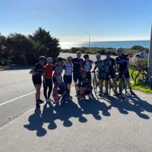 group of cyclist at roadside with the ocean in the background