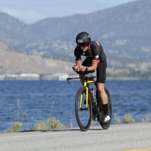 Mike Neill riding along Skaha lake at 2024 IMC 70.3 in Penticton