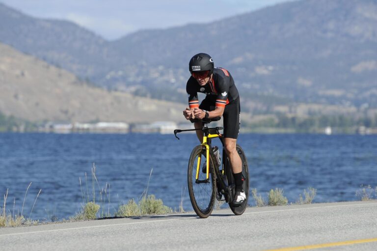 Mike Neill riding along Skaha lake at 2024 IMC 70.3 in Penticton