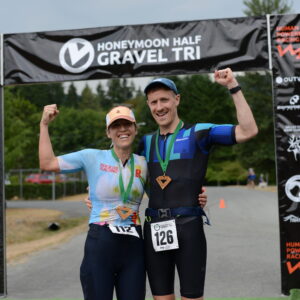 2 finishers at the finish arch at the Honeymoon Half Gravel Triathlon