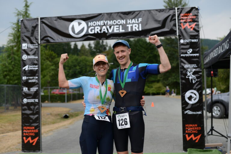2 finishers at the finish arch at the Honeymoon Half Gravel Triathlon