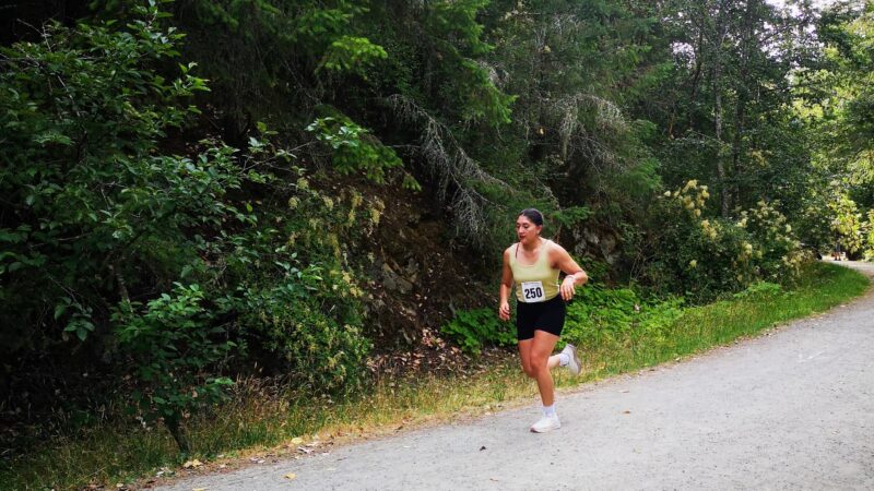 A runner comes blasting around a corner into her second lap of the trail run.