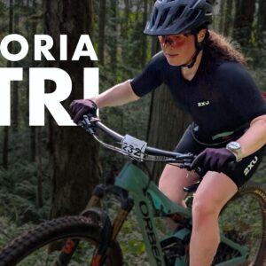 Victoria X Tri logo over top of a cyclist burning down a single track forest course.
