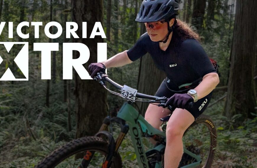 Victoria X Tri logo over top of a cyclist burning down a single track forest course.